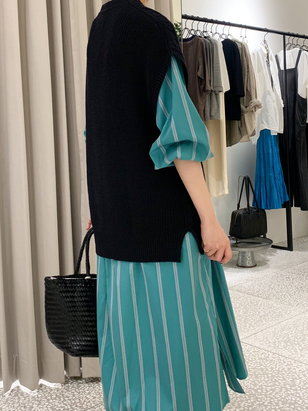 ブラック系のニット/セーター、グリーン系のワンピース、ブラック系のその他パンツを着用したレディースの秋コーディネートの5枚目の写真