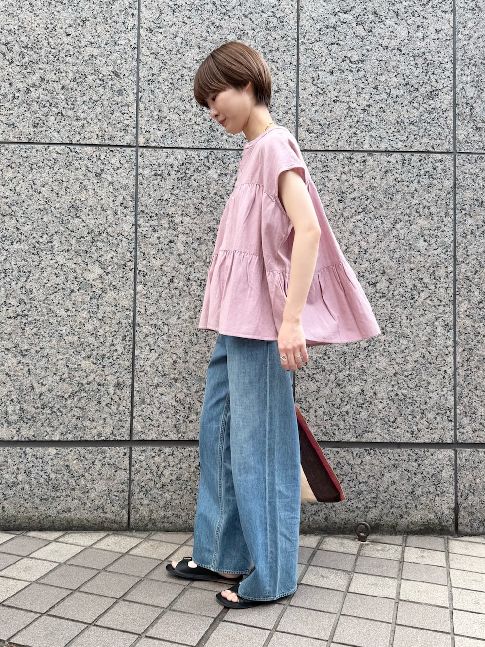 ピンク系のシャツ/ブラウス、ブルー系のデニムパンツ、ピンク系のかごバッグを着用したレディースの春コーディネートの2枚目の写真