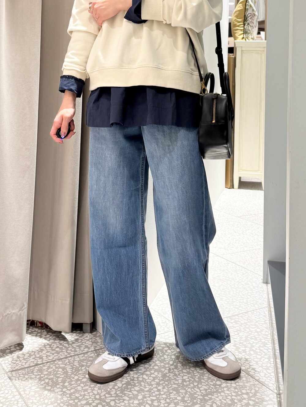 ホワイト系のスウェット、ブルー系のシャツ/ブラウス、ブラック系のショルダーバッグを着用したレディースの春コーディネートの3枚目の写真