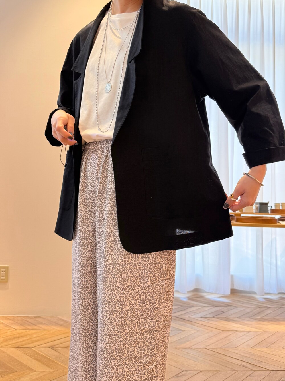 ブラック系のテーラードジャケット、ブラック系のその他パンツ、ブルー系のトートバッグを着用したレディースの夏コーディネートの5枚目の写真