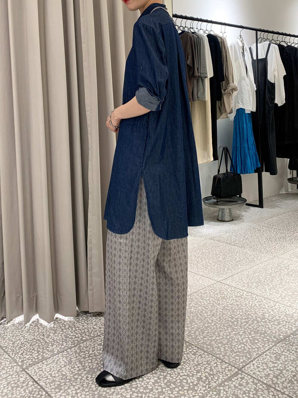 ブルー系のシャツ/ブラウス、ブラック系のトートバッグ、ベージュ系のその他パンツを着用したレディースの秋コーディネートの4枚目の写真