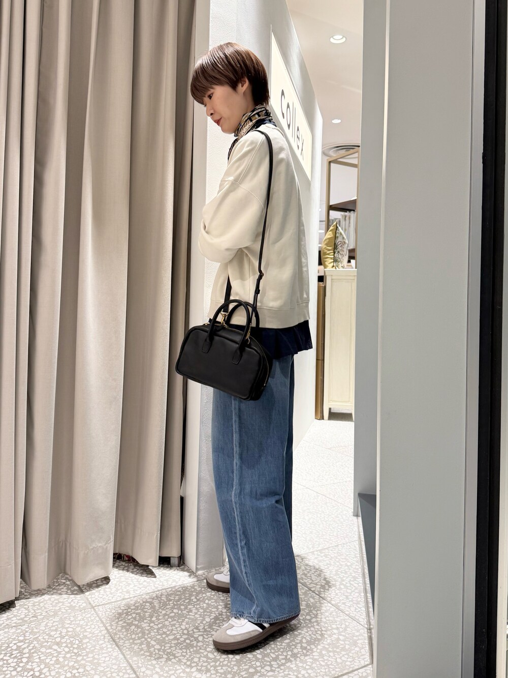 ホワイト系のスウェット、ブルー系のシャツ/ブラウス、ブラック系のショルダーバッグを着用したレディースの春コーディネートの2枚目の写真