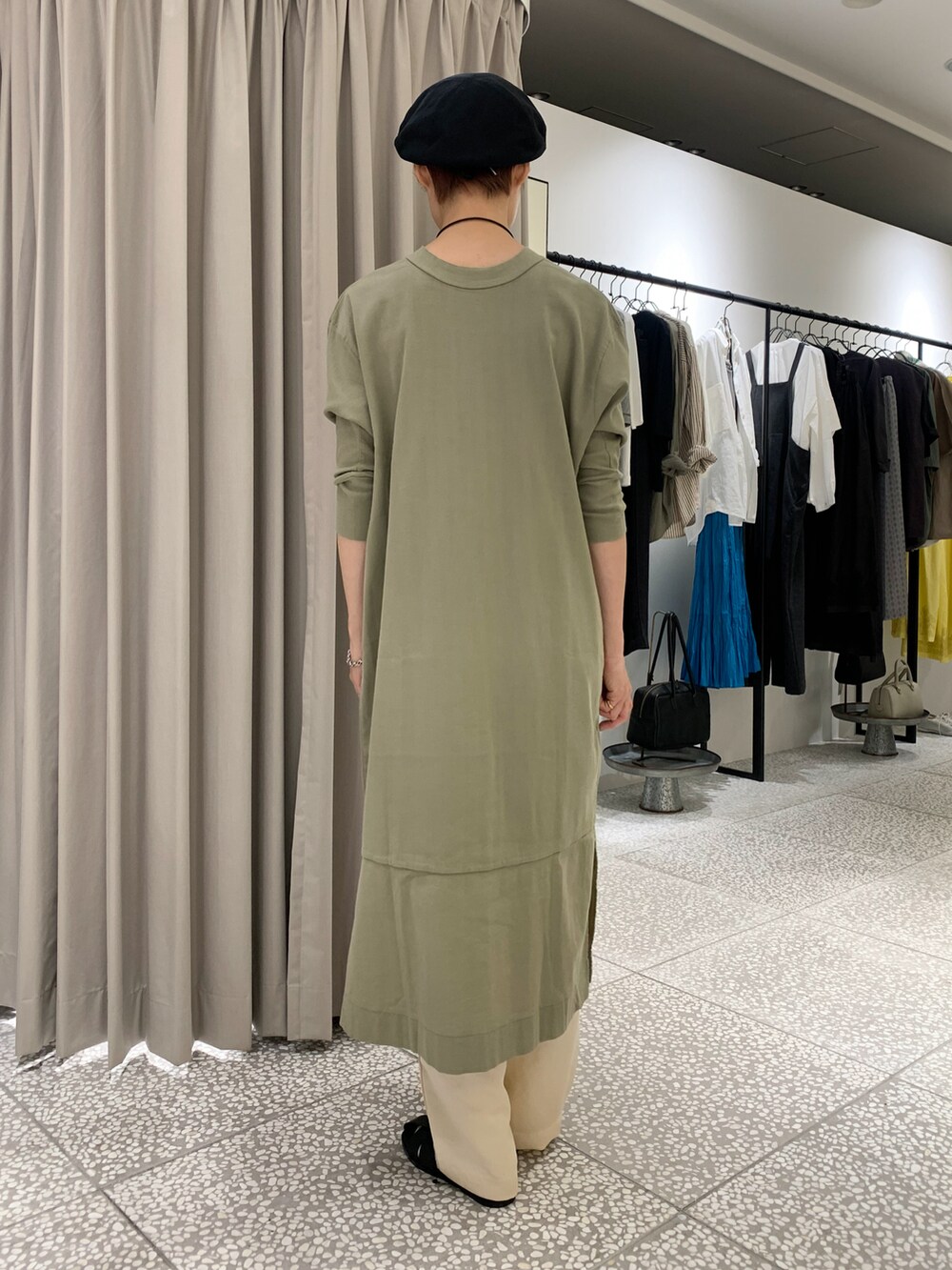 グリーン系のワンピース、ホワイト系のその他パンツ、ブラック系のサンダルを着用したレディースの秋コーディネートの3枚目の写真