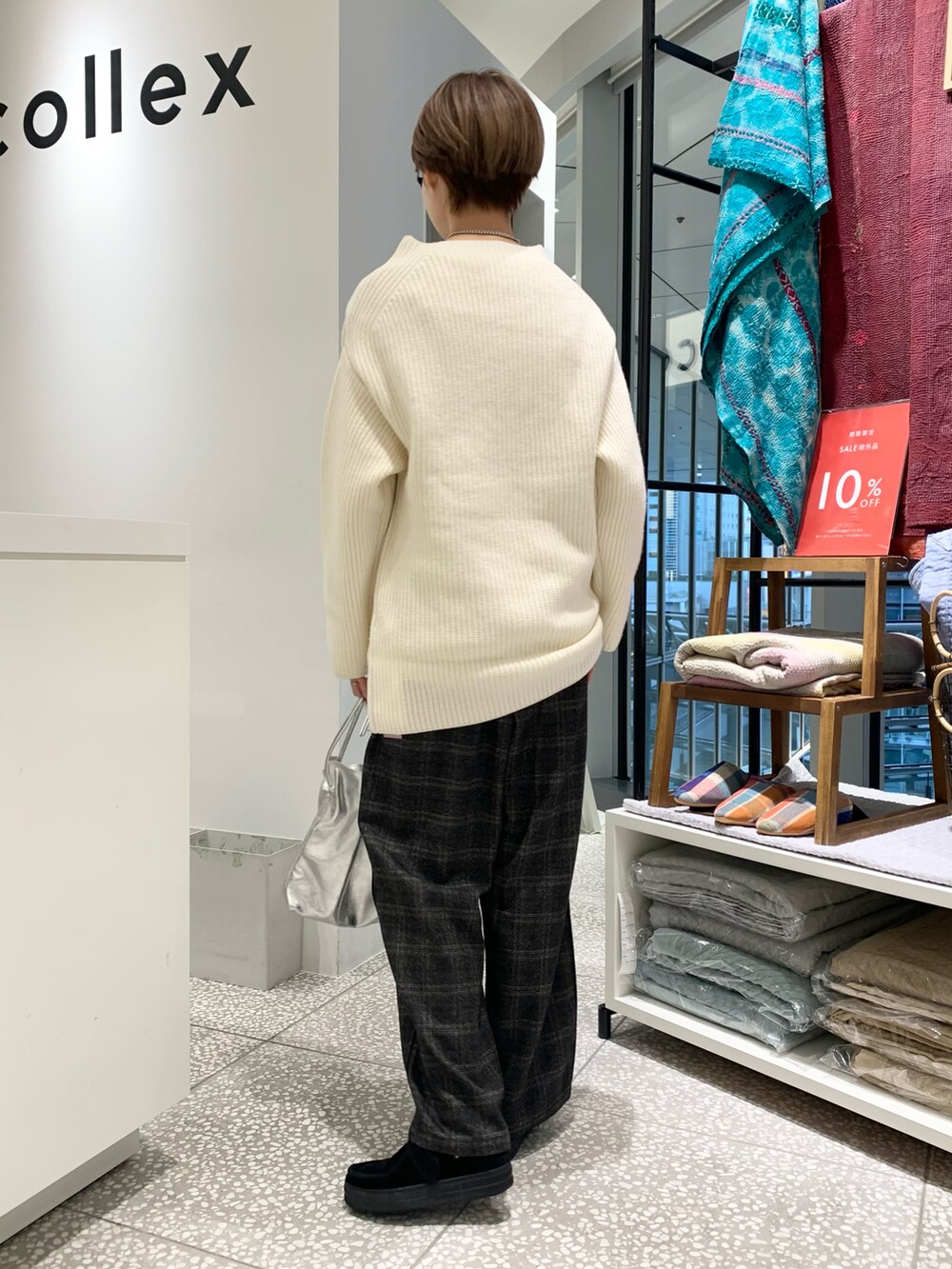 ホワイト系のニット/セーター、ブラック系のその他パンツ、シルバー系のショルダーバッグを着用したレディースの冬コーディネートの2枚目の写真
