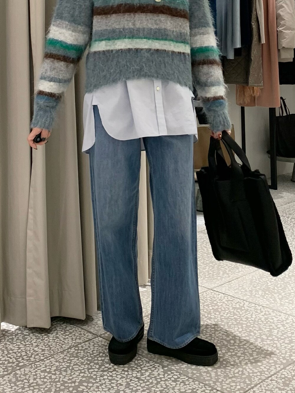 ブルー系のニット/セーター、ブルー系のシャツ/ブラウス、ブルー系のデニムパンツを着用したレディースの冬コーディネートの4枚目の写真