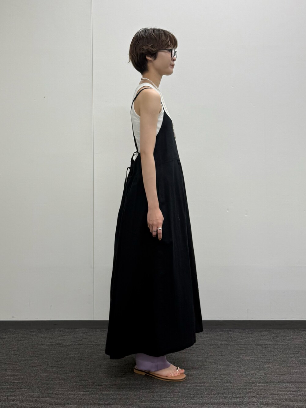 ブラック系のワンピース、ゴールド系のかごバッグ、グリーン系のその他パンツを着用したレディースの夏コーディネートの3枚目の写真