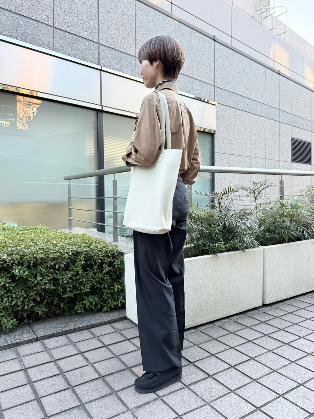 ブラウン系のシャツ/ブラウス、ホワイト系のトートバッグを着用したレディースの春コーディネートの2枚目の写真