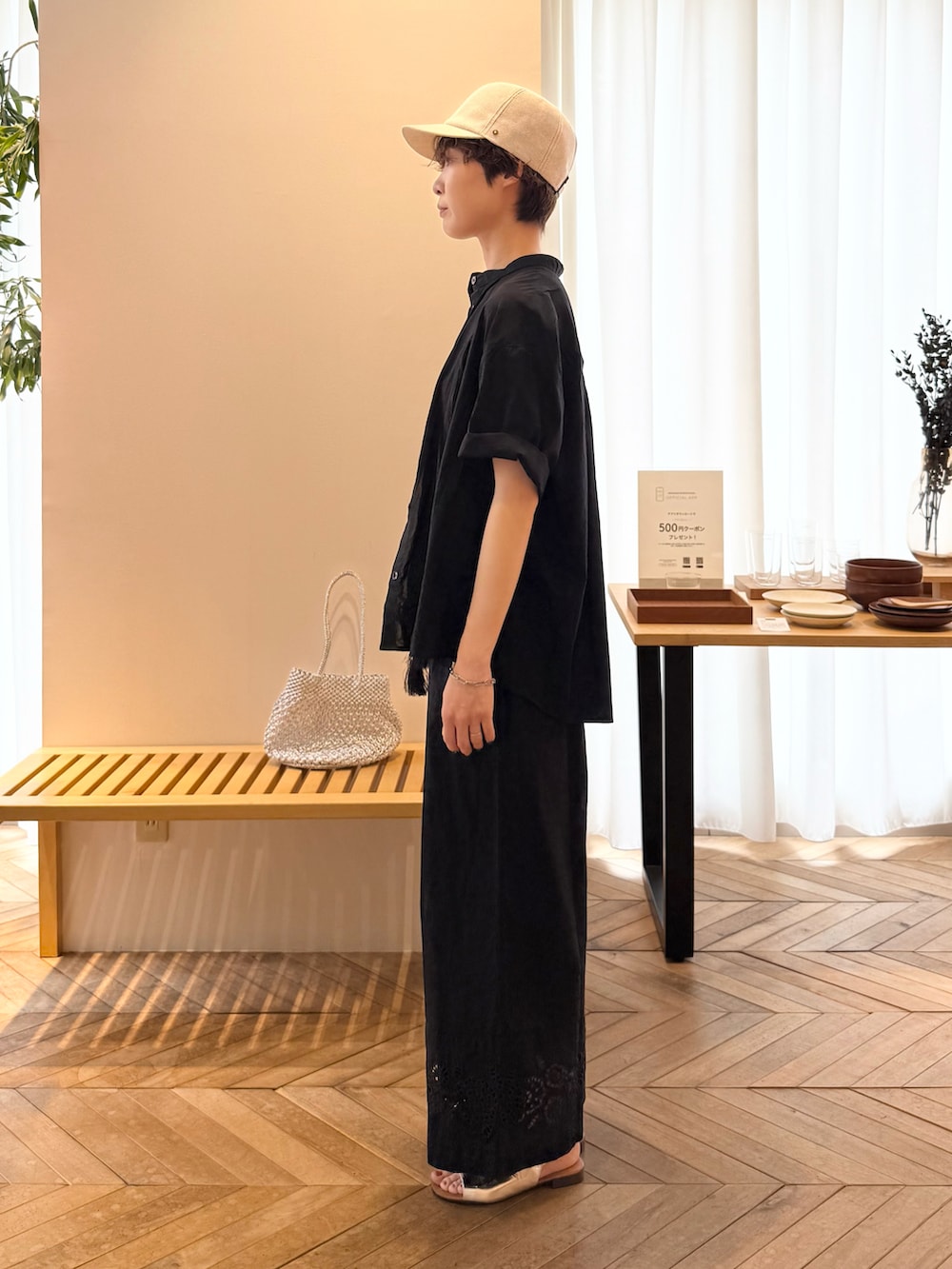 ブラック系のシャツ/ブラウス、ゴールド系のかごバッグ、ブラック系のその他パンツを着用したレディースの夏コーディネートの2枚目の写真