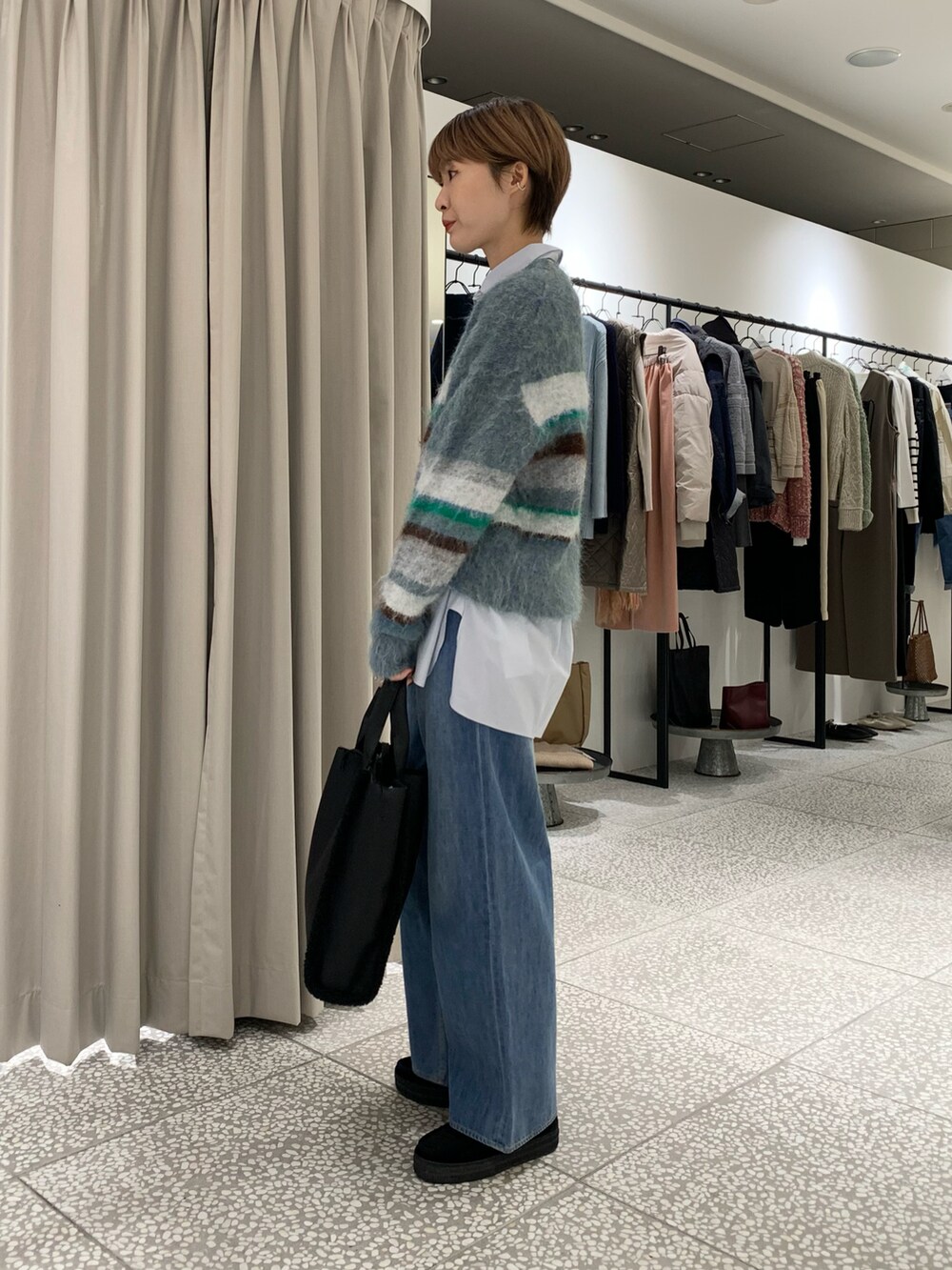 ブルー系のニット/セーター、ブルー系のシャツ/ブラウス、ブルー系のデニムパンツを着用したレディースの冬コーディネートの2枚目の写真