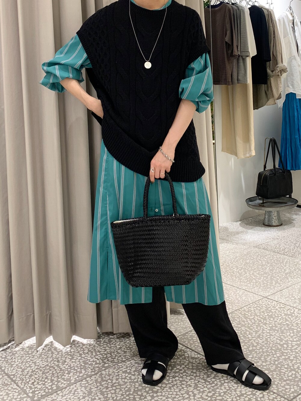 ブラック系のニット/セーター、グリーン系のワンピース、ブラック系のその他パンツを着用したレディースの秋コーディネートの4枚目の写真