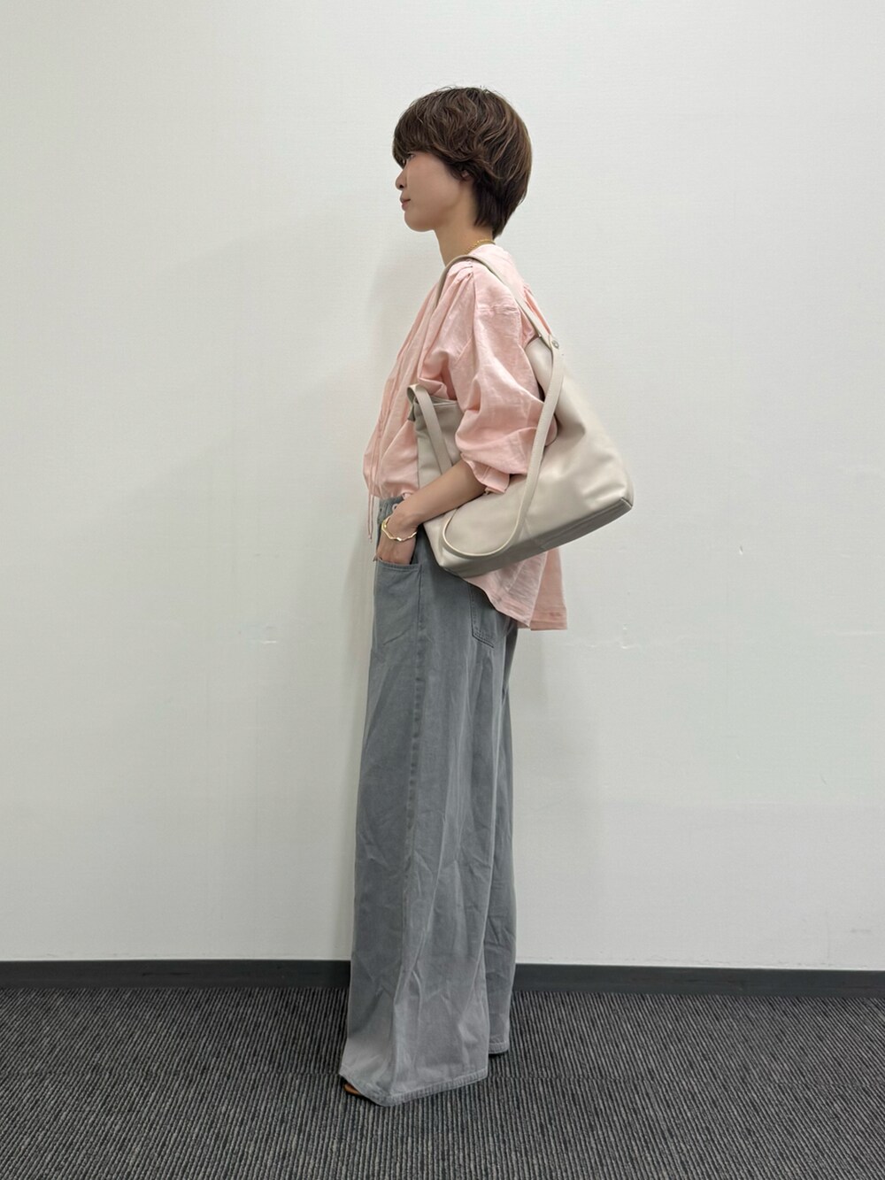 ピンク系のシャツ/ブラウス、グレー系のトートバッグ、グレー系のデニムパンツを着用したレディースの夏コーディネートの2枚目の写真
