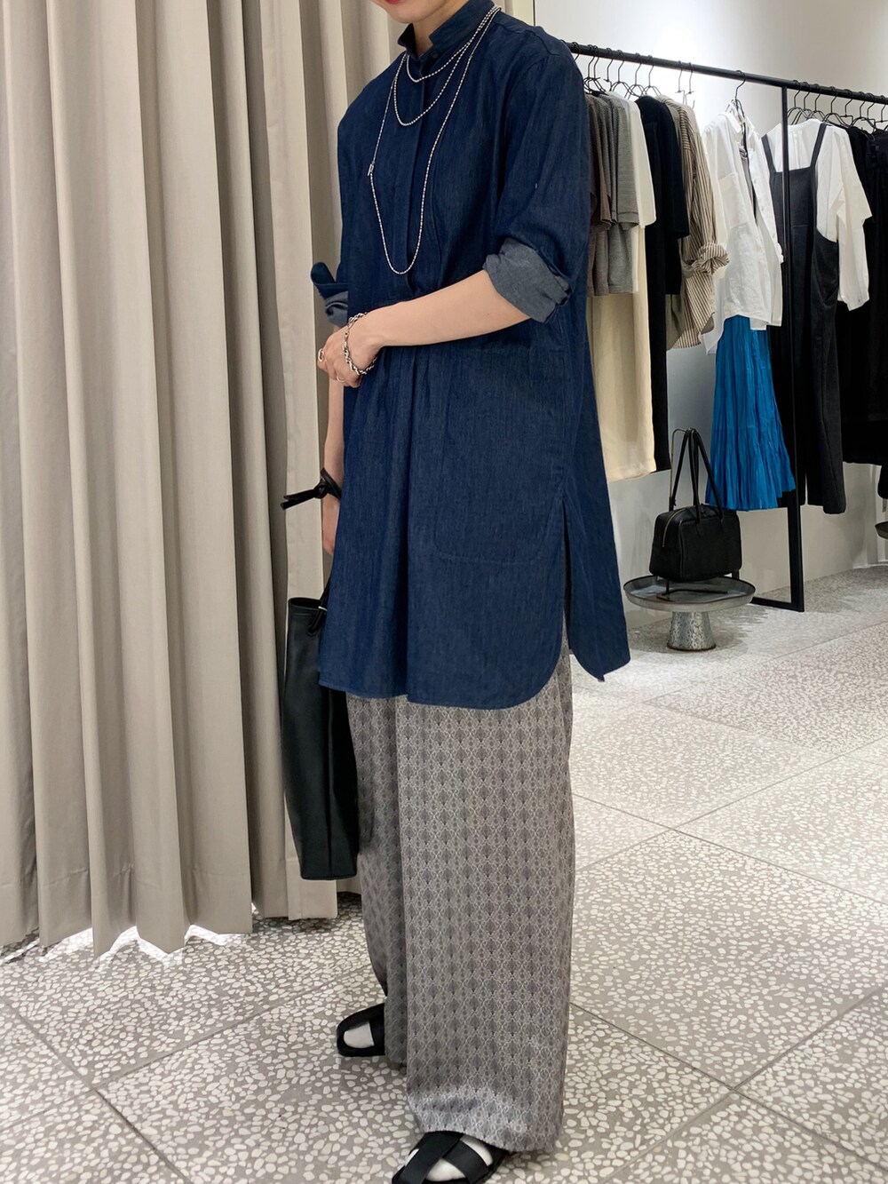 ブルー系のシャツ/ブラウス、ブラック系のトートバッグ、ベージュ系のその他パンツを着用したレディースの秋コーディネートの2枚目の写真