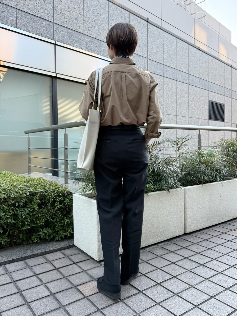 ブラウン系のシャツ/ブラウス、ホワイト系のトートバッグを着用したレディースの春コーディネートの3枚目の写真