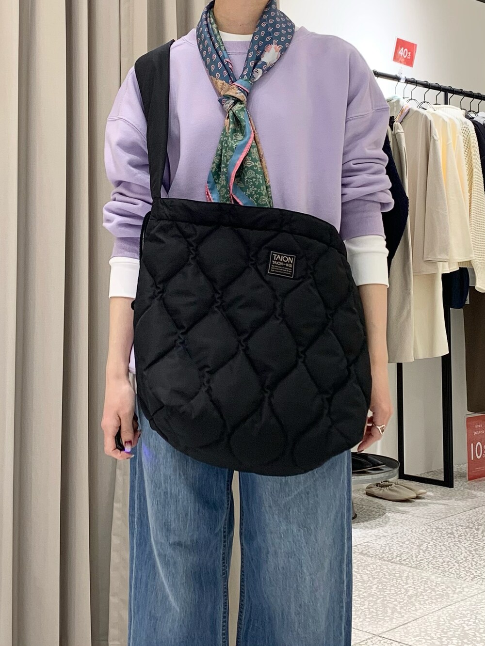 パープル系のスウェット、ブラック系のショルダーバッグ、ブルー系のデニムパンツを着用したレディースの冬コーディネートの5枚目の写真