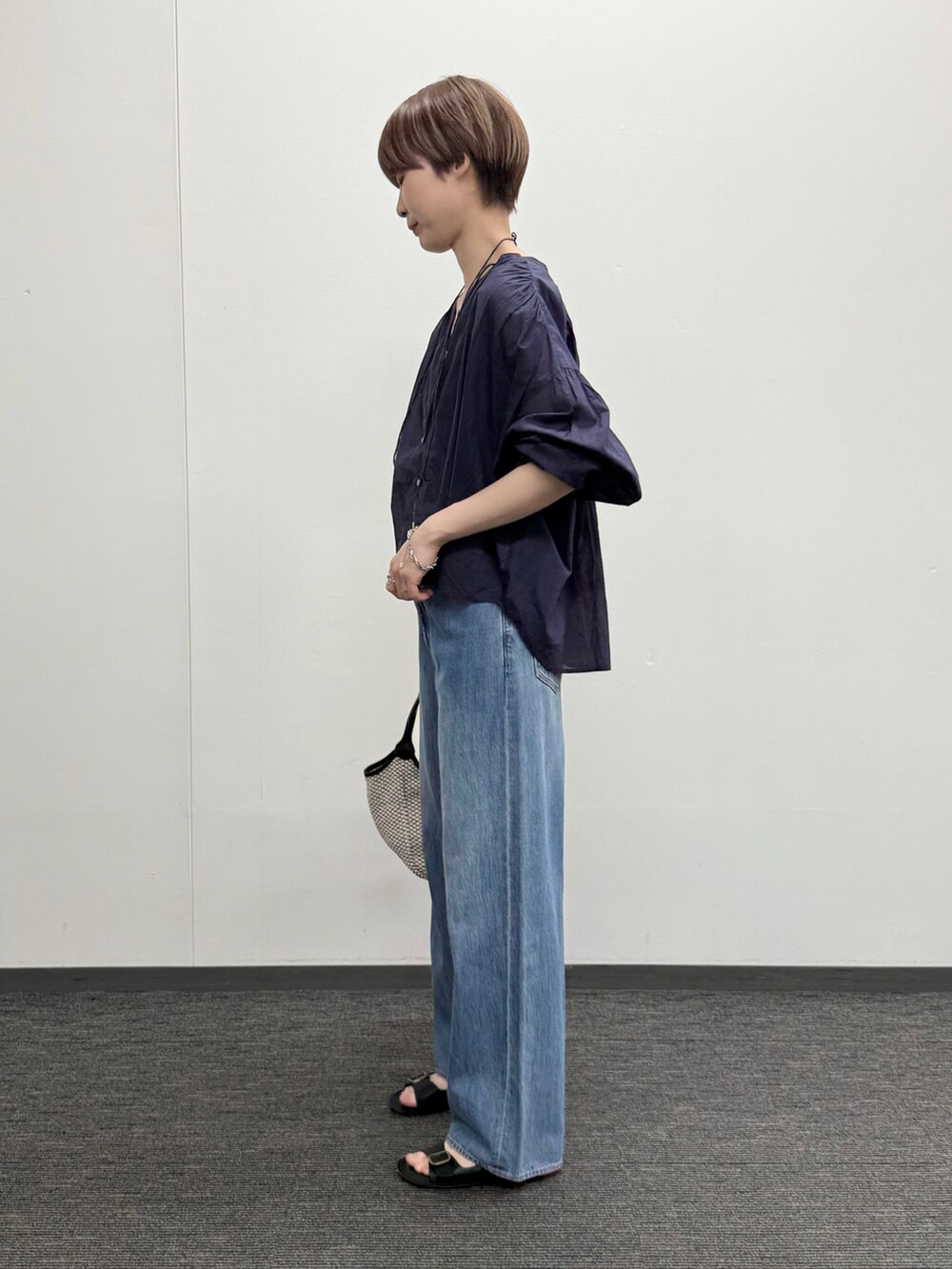 ブルー系のシャツ/ブラウス、ブルー系のデニムパンツ、ブラック系のかごバッグを着用したレディースの春コーディネートの2枚目の写真