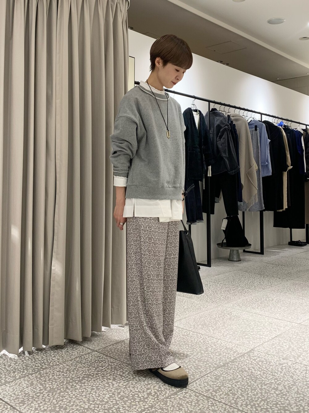 グレー系のスウェット、ホワイト系のシャツ/ブラウス、ブラック系のトートバッグを着用したレディースの秋コーディネートの4枚目の写真