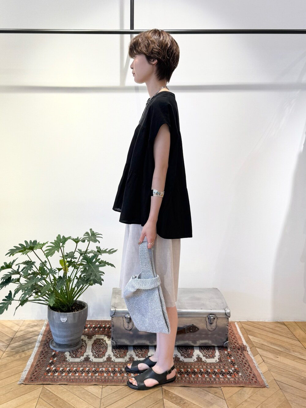 ブラック系のシャツ/ブラウス、シルバー系のかごバッグ、ブラック系のサンダルを着用したレディースの夏コーディネートの2枚目の写真