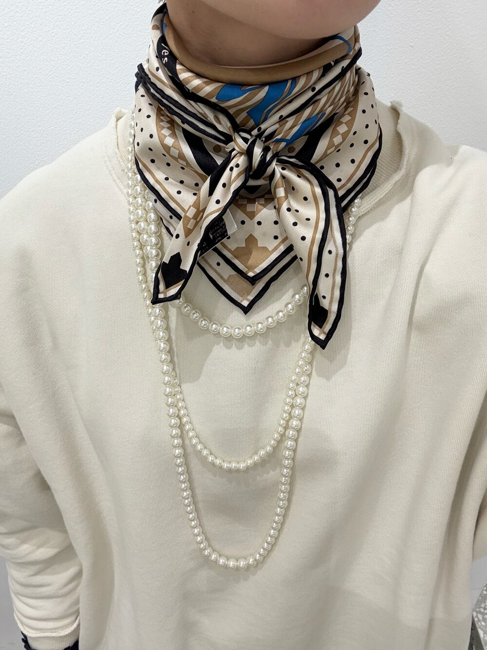 ホワイト系のスウェット、ブルー系のシャツ/ブラウス、ブラック系のショルダーバッグを着用したレディースの春コーディネートの4枚目の写真