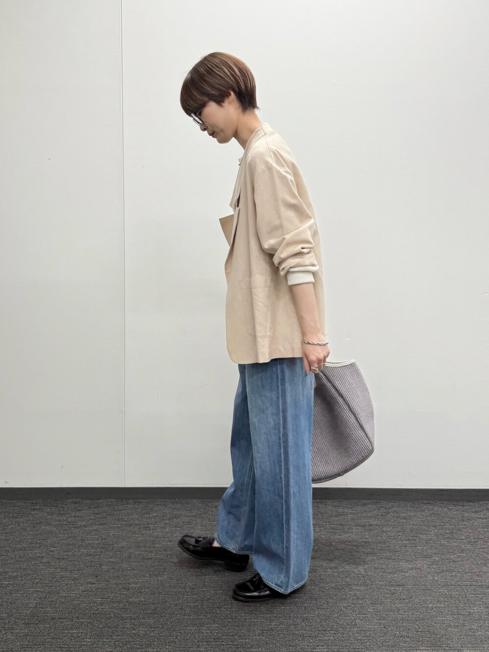 ホワイト系のカーディガン/ボレロ、ベージュ系のテーラードジャケット、ブルー系のデニムパンツを着用したレディースの春コーディネートの2枚目の写真