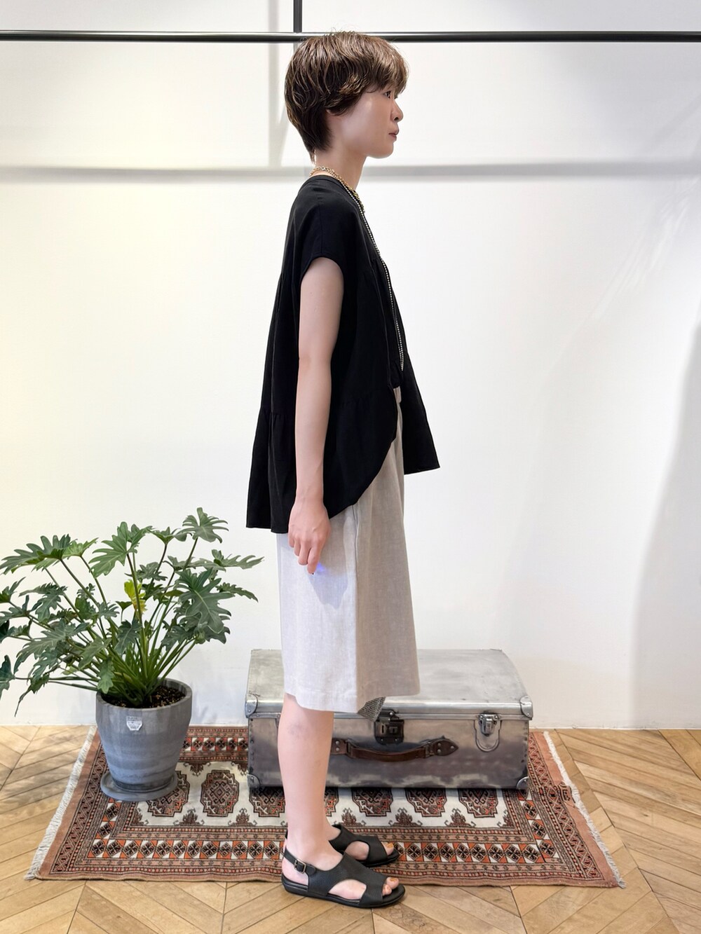 ブラック系のシャツ/ブラウス、シルバー系のかごバッグ、ブラック系のサンダルを着用したレディースの夏コーディネートの3枚目の写真