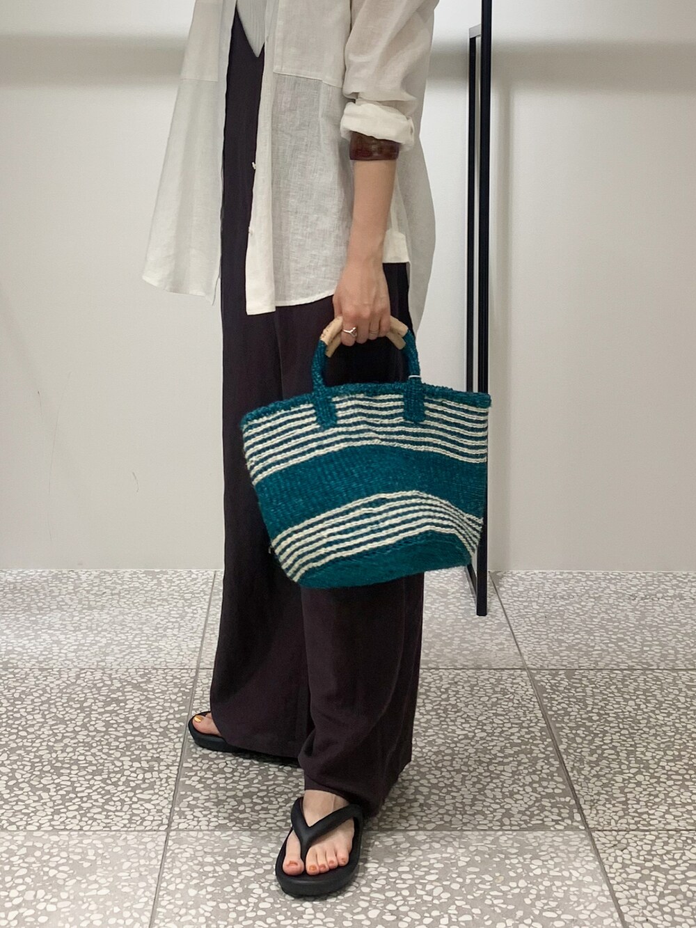 ホワイト系のタンクトップ、グレー系のサロペット/オーバーオール、グリーン系のかごバッグを着用したレディースの夏コーディネートの3枚目の写真