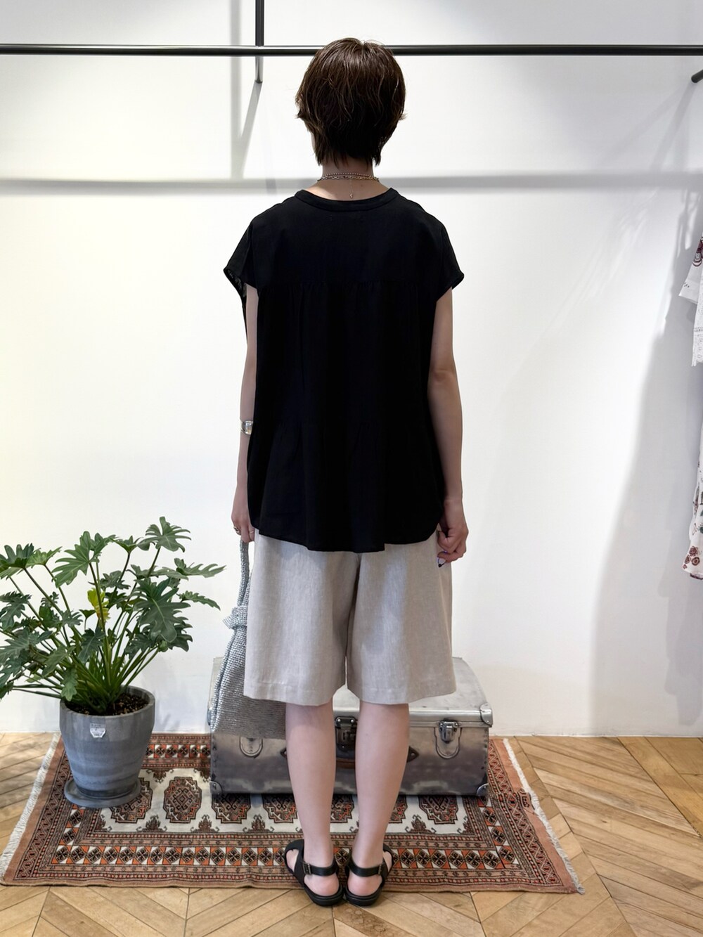 ブラック系のシャツ/ブラウス、シルバー系のかごバッグ、ブラック系のサンダルを着用したレディースの夏コーディネートの4枚目の写真