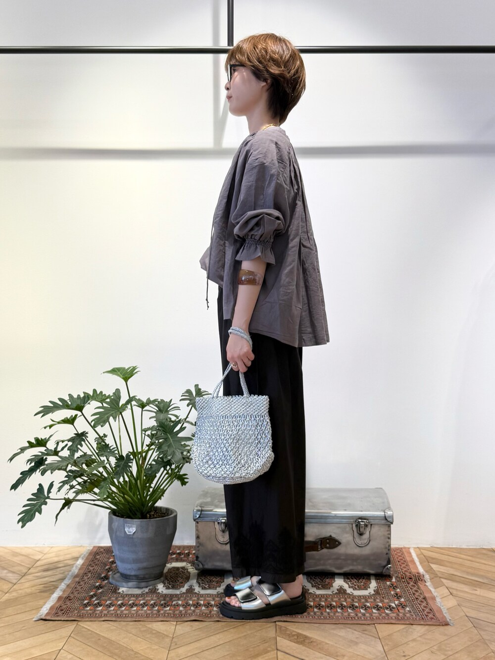 グレー系のシャツ/ブラウス、ブラック系のその他パンツ、シルバー系のかごバッグを着用したレディースの夏コーディネートの2枚目の写真
