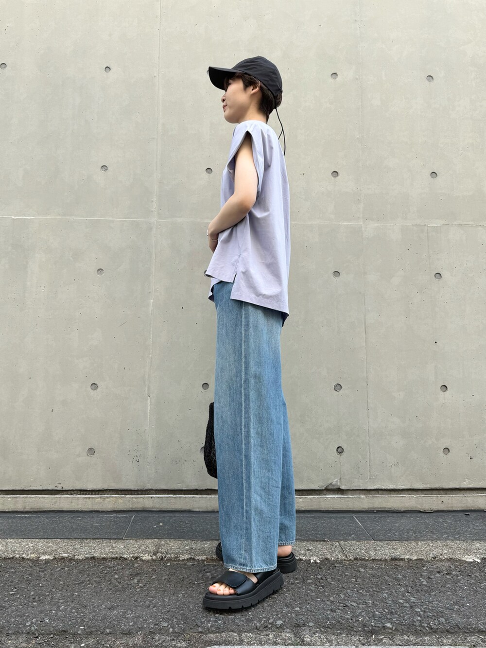 パープル系のTシャツ/カットソー、ブルー系のデニムパンツ、ブラック系のかごバッグを着用したレディースの夏コーディネートの2枚目の写真