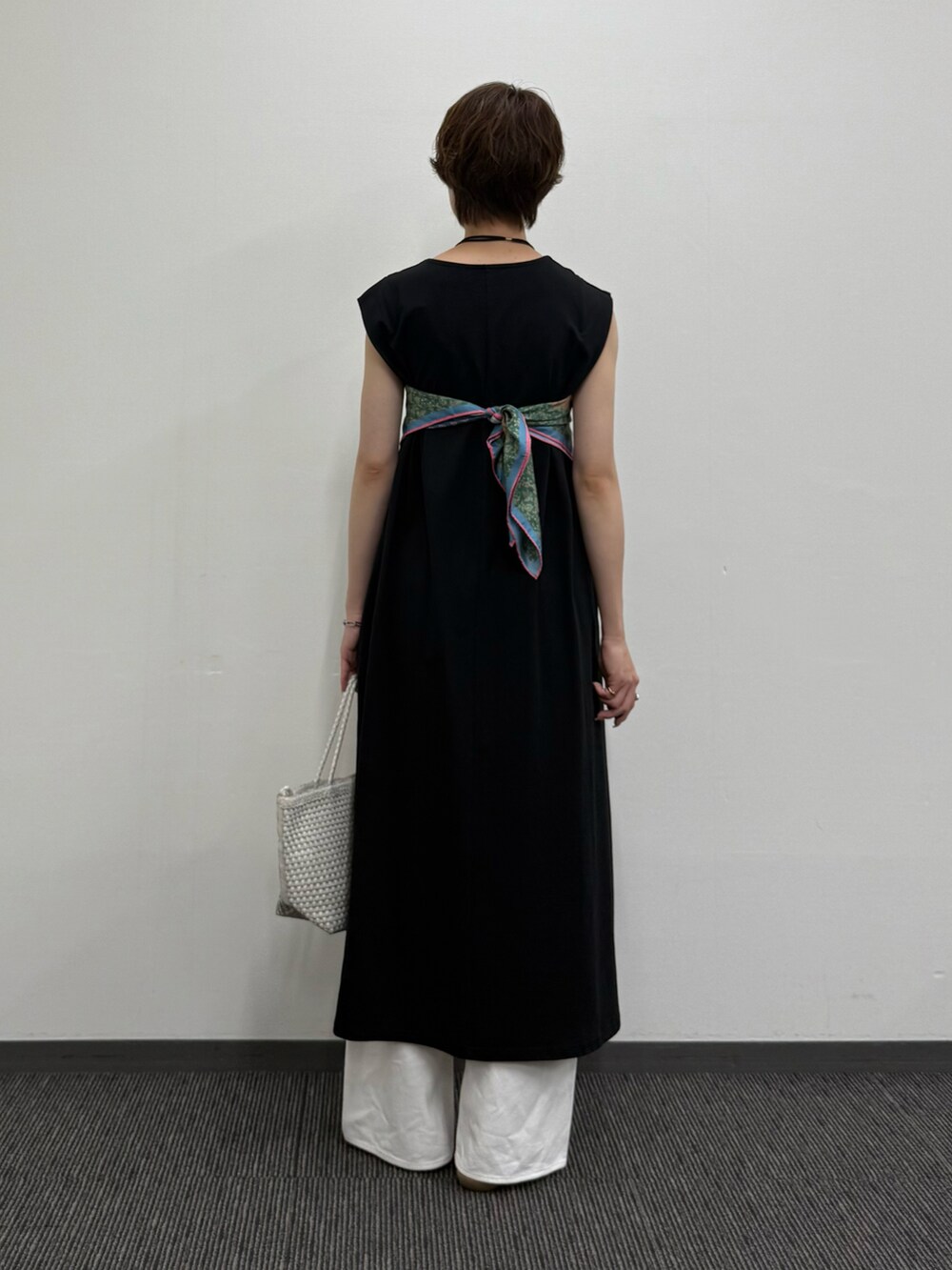 ブラック系のワンピース、ホワイト系のトートバッグ、ブラウン系のサンダルを着用したレディースの夏コーディネートの3枚目の写真