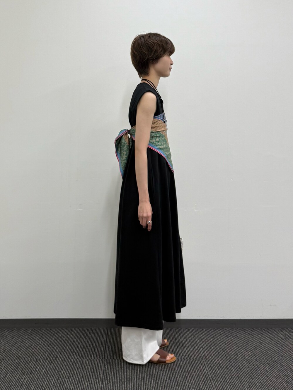 ブラック系のワンピース、ホワイト系のトートバッグ、ブラウン系のサンダルを着用したレディースの夏コーディネートの4枚目の写真