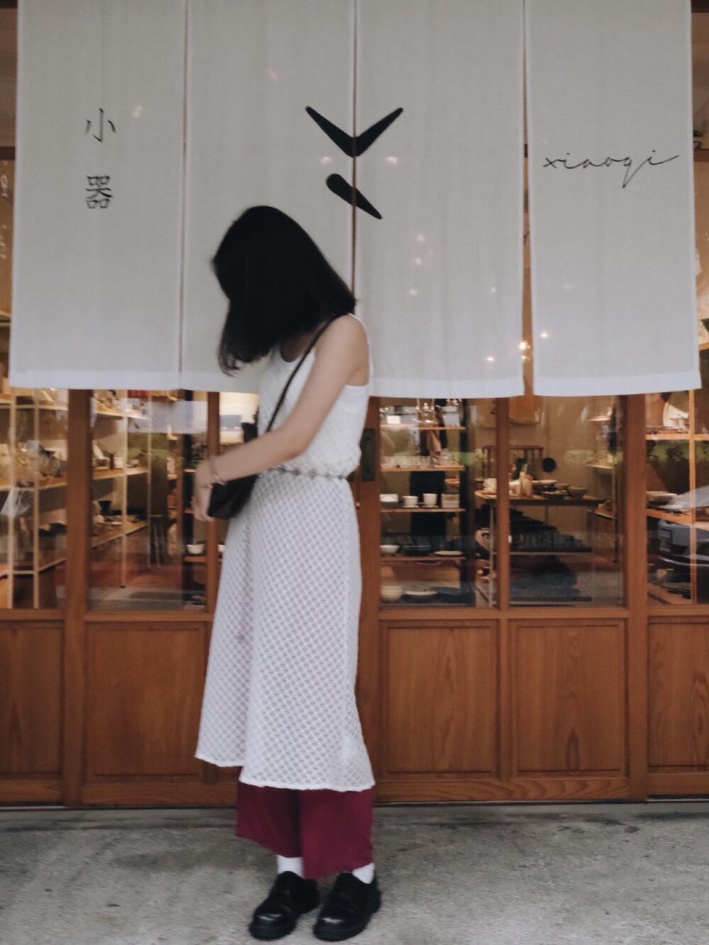 ホワイト系のワンピース/ドレス、レッド系のチノパンツ、ブラック系のブーティを着用したレディースの秋コーディネートの2枚目の写真