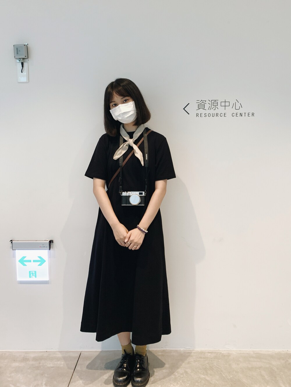 ブラック系のチュニック、ブラック系のブーティ、ベージュ系のストール/ショールを着用したレディースの夏コーディネートの2枚目の写真