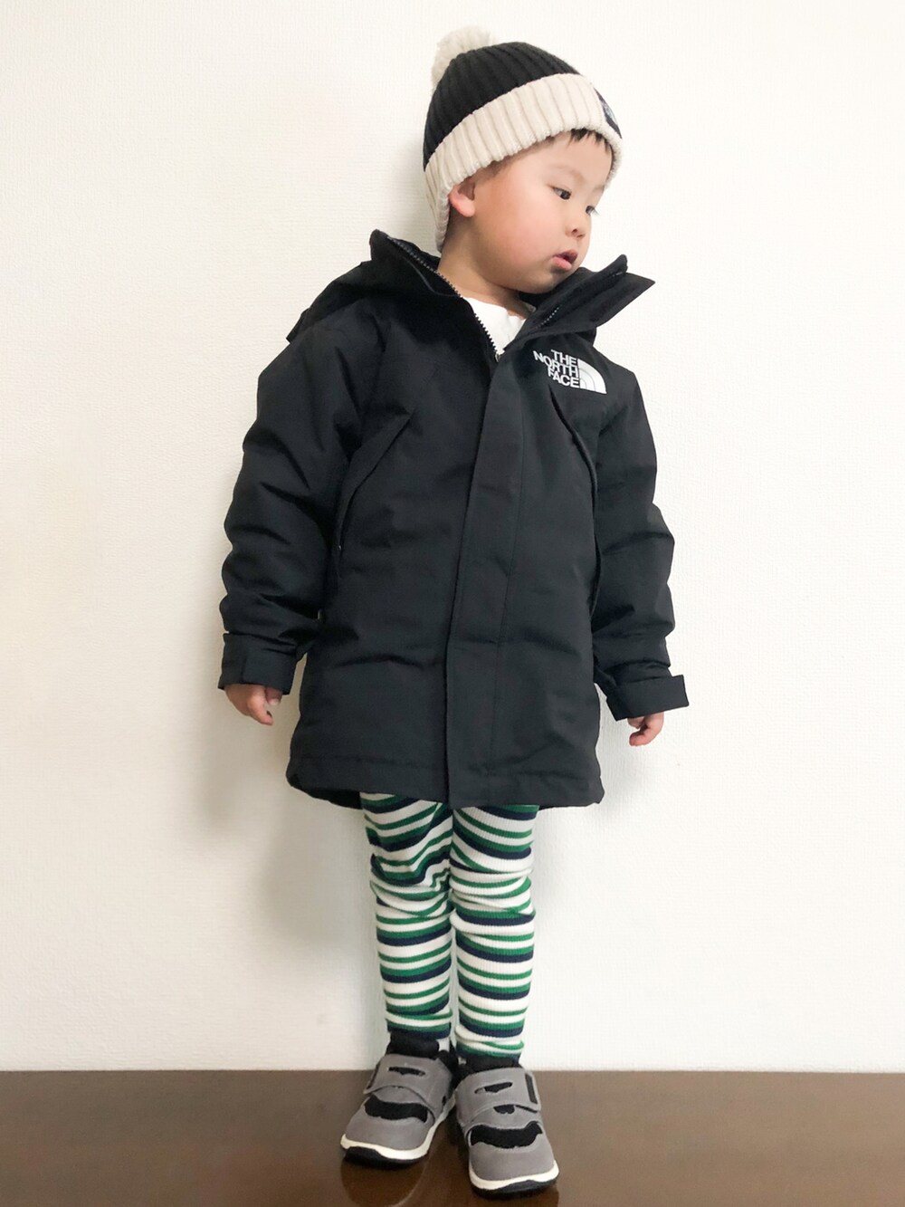 ブラック系のマウンテンパーカー、ブラック系のスニーカー、ホワイト系のTシャツ/カットソーを着用したキッズの冬コーディネートの2枚目の写真