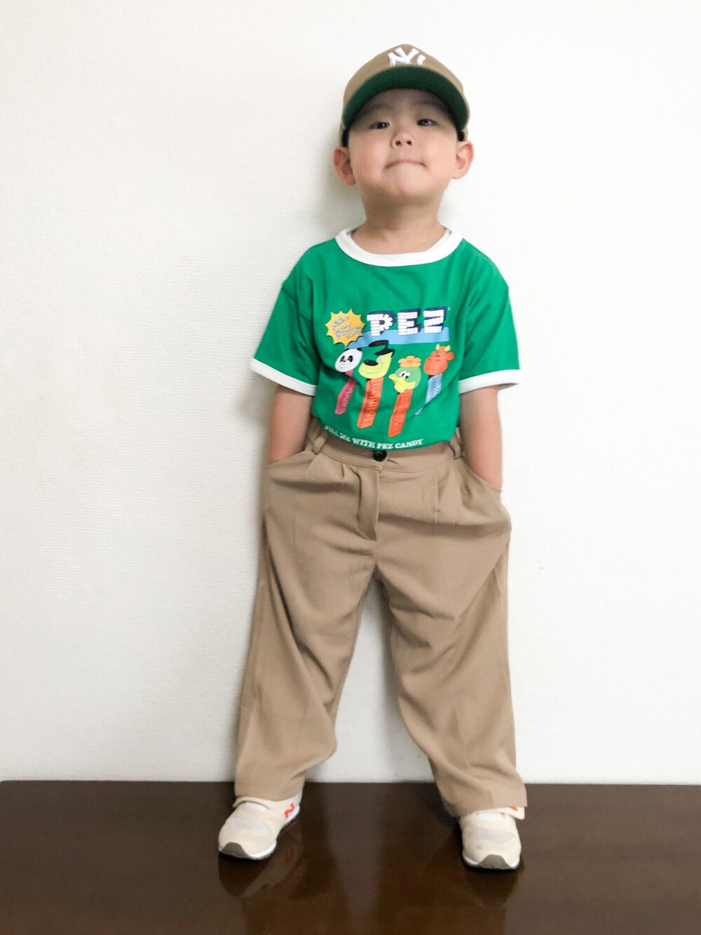 グリーン系のTシャツ/カットソー、ベージュ系のスラックス、ベージュ系のスニーカーを着用したキッズの春コーディネートの2枚目の写真