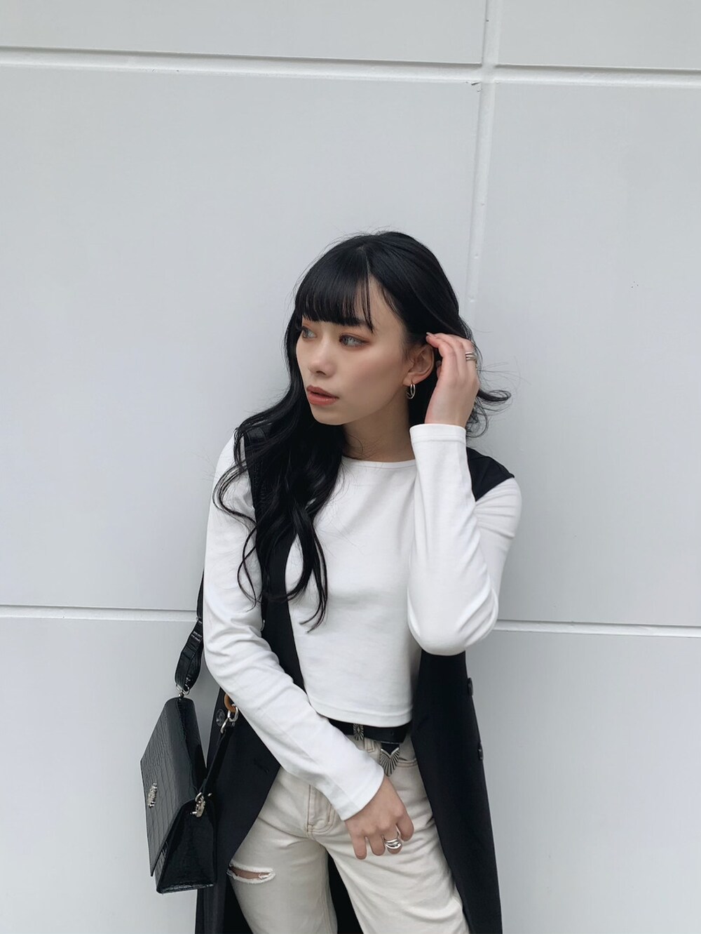 ホワイト系のTシャツ/カットソー、ブラック系のトレンチコート、ブラック系のパンプスを着用したレディースの春コーディネートの3枚目の写真