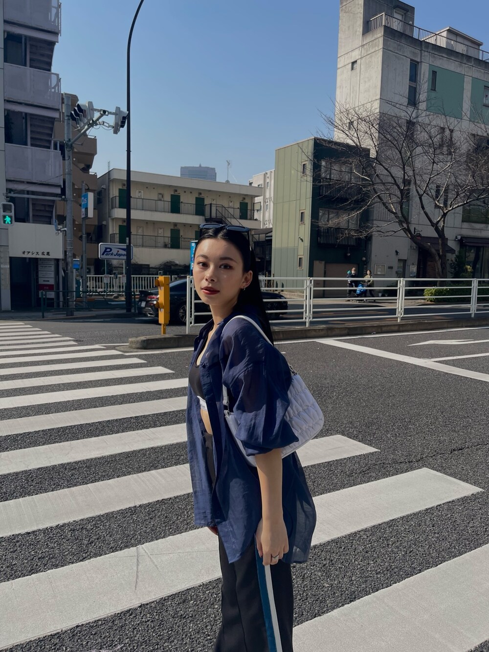 ブルー系のシャツ/ブラウス、ブラック系のスラックスを着用したレディースの春コーディネートの3枚目の写真