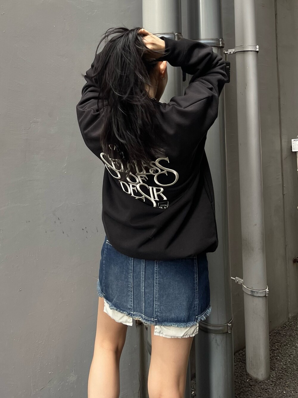 その他のチェスターコート、ブラック系のスウェット、ブルー系のデニムスカートを着用したレディースの秋コーディネートの4枚目の写真