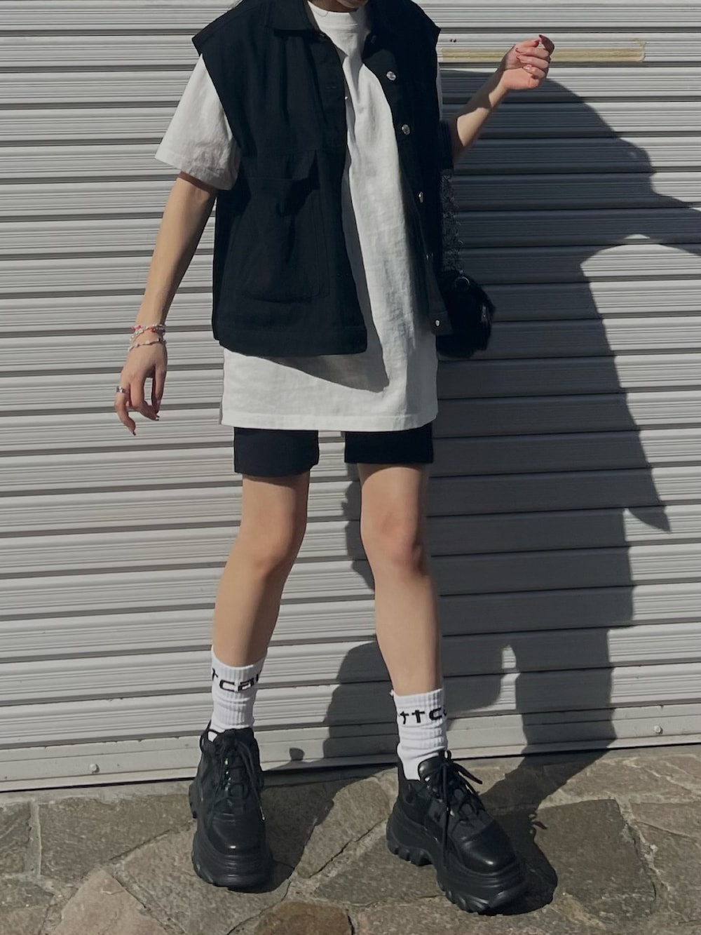 ホワイト系のTシャツ/カットソー、ブラック系のその他パンツ、ブラック系のスニーカーを着用したレディースの春コーディネートの6枚目の写真