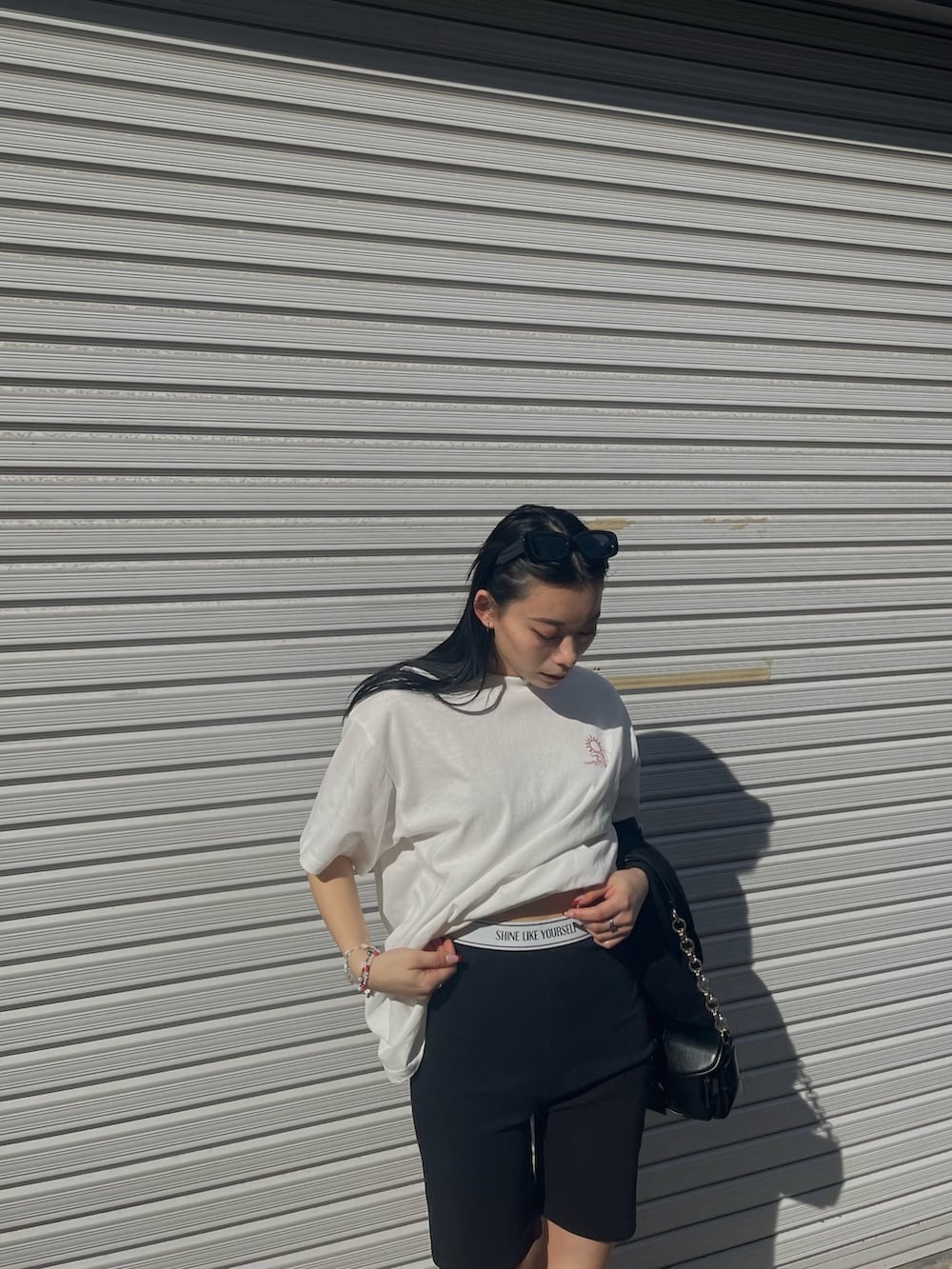 ホワイト系のTシャツ/カットソー、ブラック系のその他パンツ、ブラック系のスニーカーを着用したレディースの春コーディネートの3枚目の写真