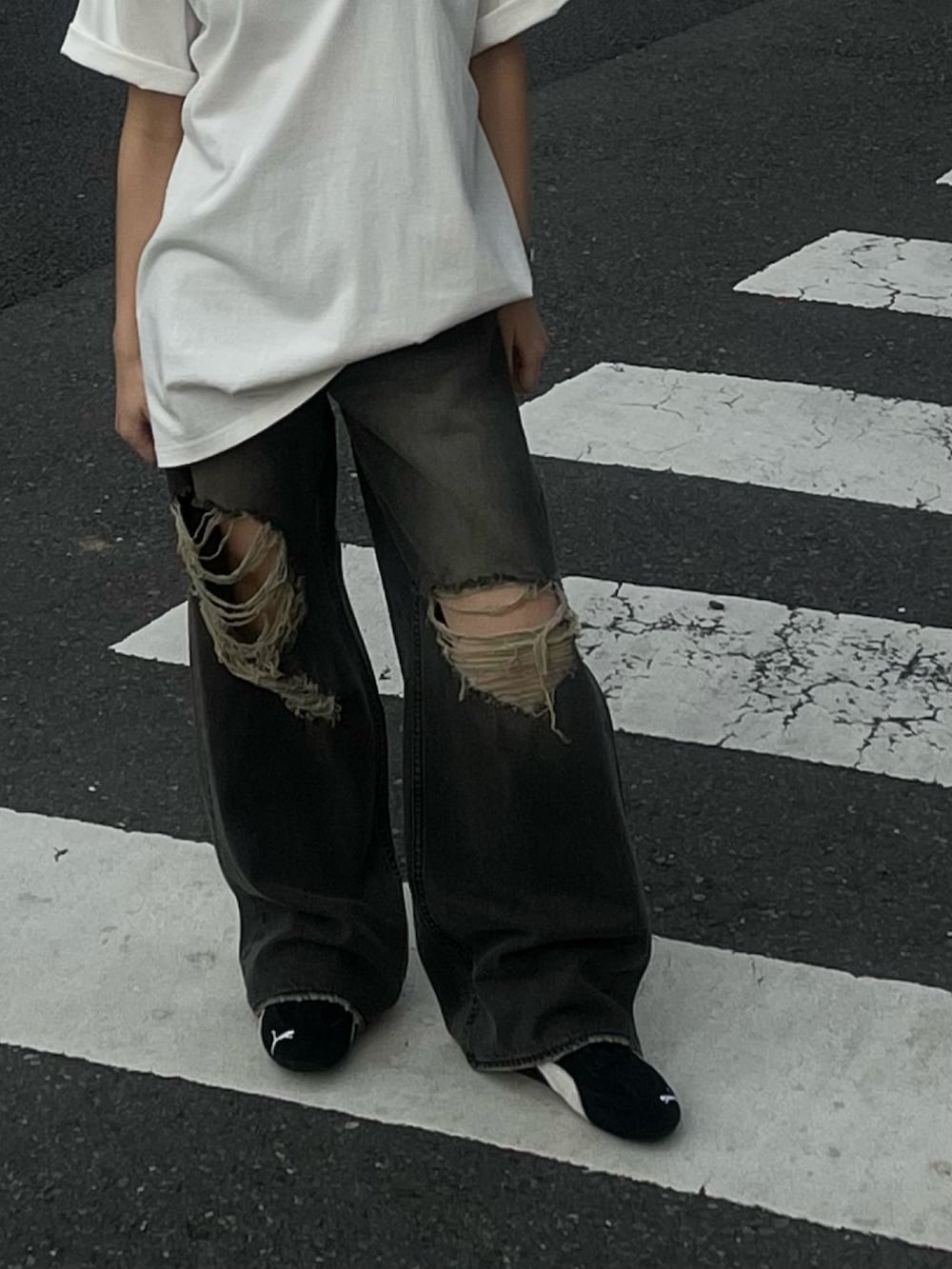 ホワイト系のTシャツ/カットソー、ブラック系のデニムパンツ、ブラック系のスニーカーを着用したレディースの春コーディネートの3枚目の写真