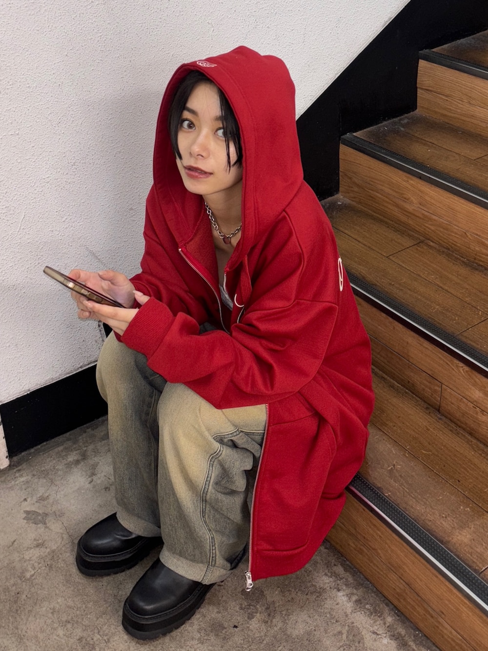 レッド系のパーカーを着用したレディースの夏コーディネートの2枚目の写真