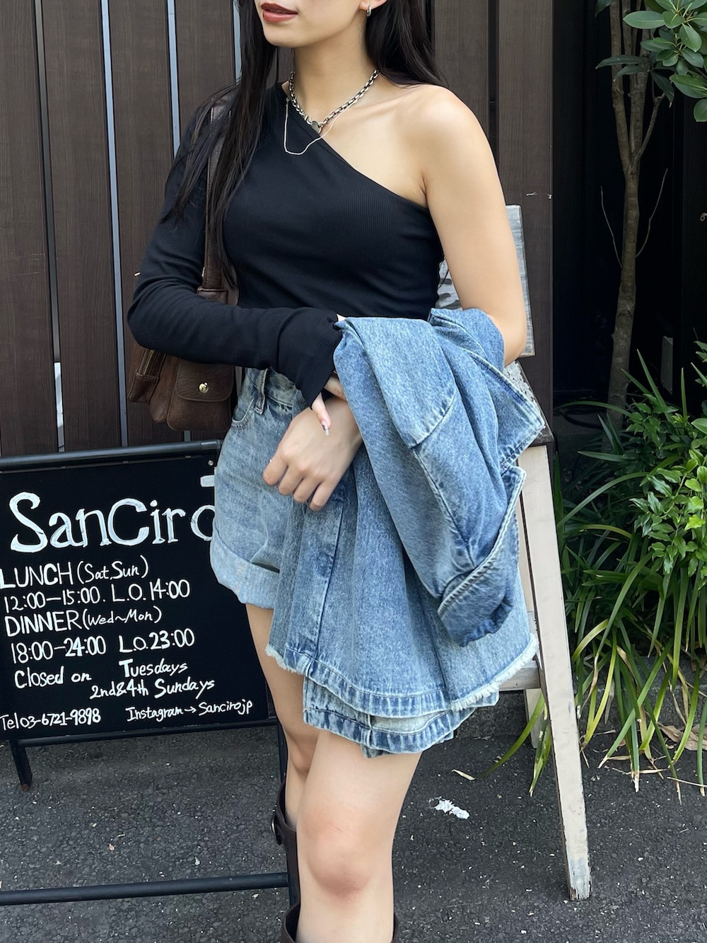 ブルー系のデニムジャケット、ブラック系のTシャツ/カットソー、ブラウン系のブーツを着用したレディースの夏コーディネートの5枚目の写真