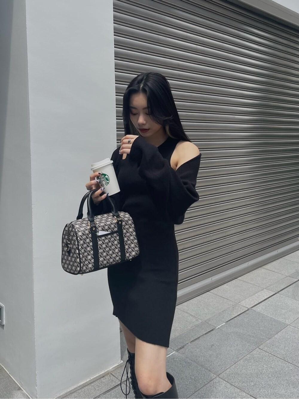 ブラック系のブーツ、ブラック系のワンピース、ブラック系のボストンバッグを着用したレディースの秋コーディネートの3枚目の写真