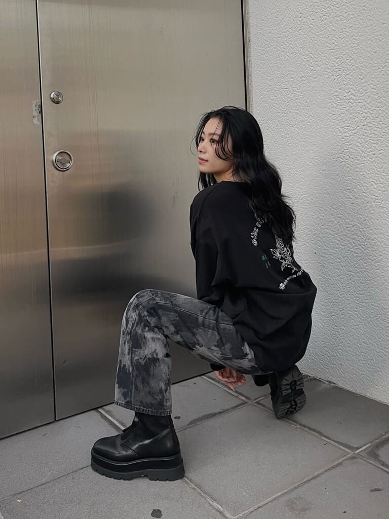 ブラック系のデニムパンツ、ブラック系のブーツ、ブラック系のTシャツ/カットソーを着用したレディースの冬コーディネートの4枚目の写真