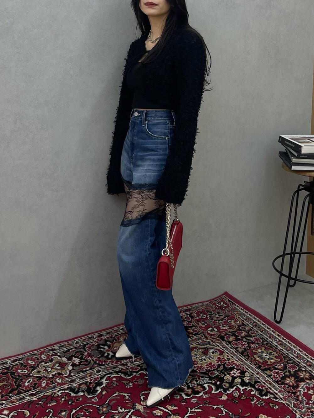 ブラック系のニット/セーター、ブルー系のデニムパンツを着用したレディースの春コーディネートの2枚目の写真