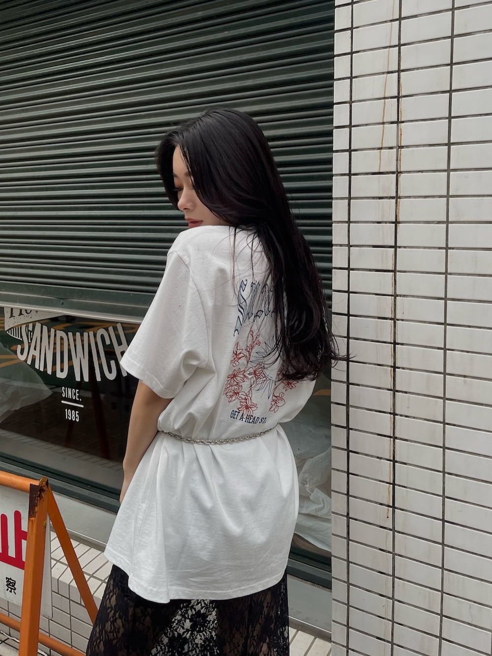 ホワイト系のTシャツ/カットソー、ブラック系のスカートを着用したレディースの春コーディネートの2枚目の写真