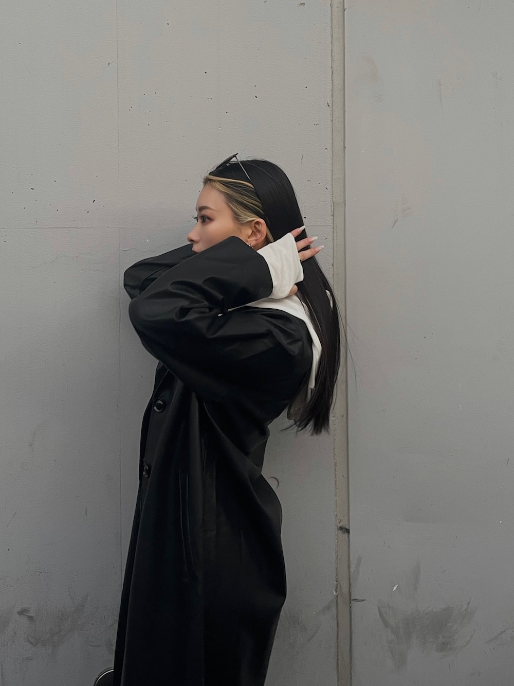 ブラック系のチェスターコート、レッド系のブーツ、ブラック系のデニムパンツを着用したレディースの冬コーディネートの5枚目の写真