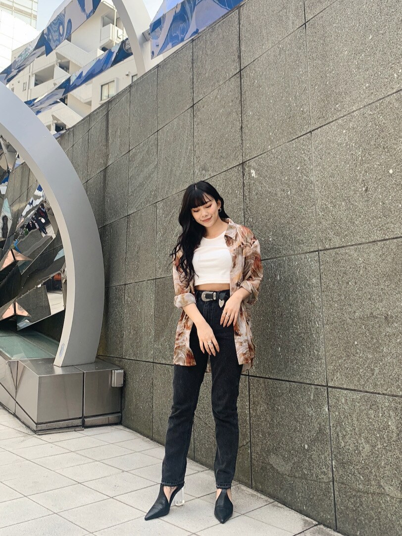 ブラック系のデニムパンツ、ブラック系のパンプス、ホワイト系のTシャツ/カットソーを着用したレディースの春コーディネートの3枚目の写真