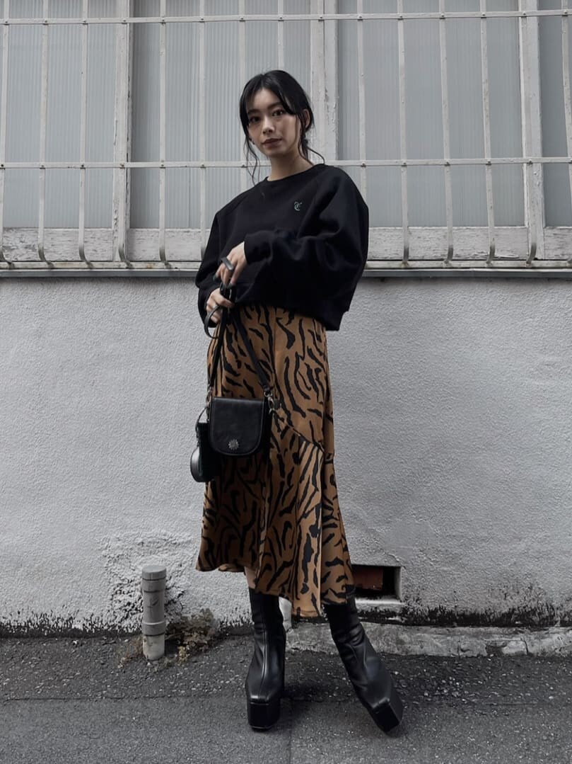 ブラック系のブーツ、ブラック系のショルダーバッグ、その他のスカートを着用したレディースの秋コーディネートの6枚目の写真