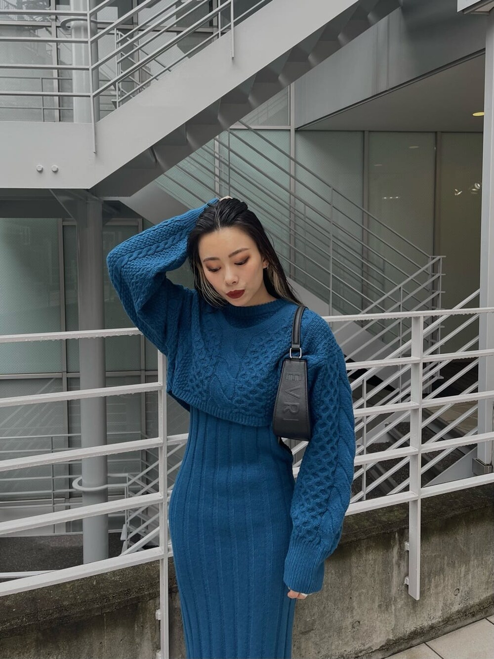 ブルー系のワンピース、ブラック系のハンドバッグ、ブラック系のブーツを着用したレディースの秋コーディネートの5枚目の写真